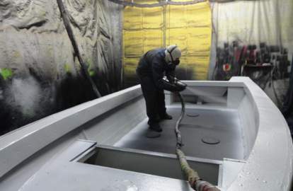 An applicator spraying Bullet Liner on a boat.