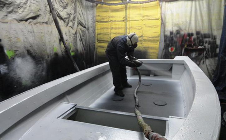 An applicator spraying Bullet Liner on a boat.